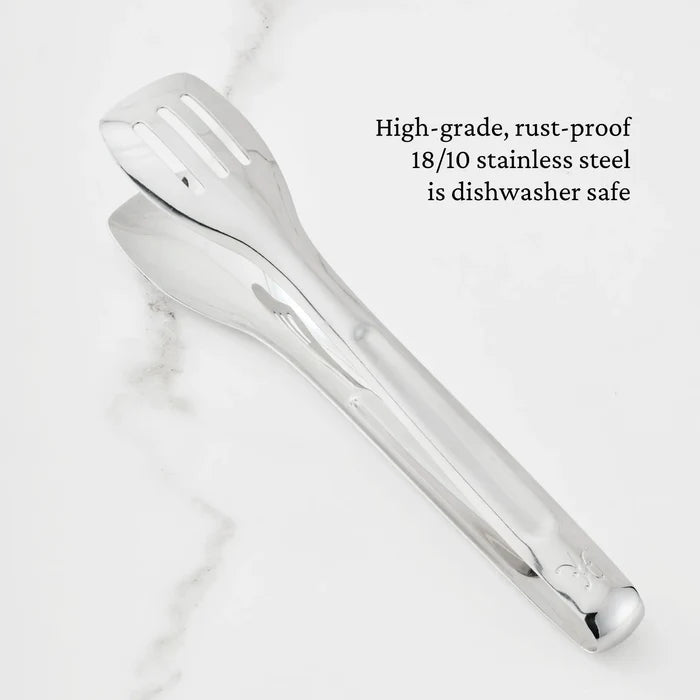 The Hestan Provisions® 10-inch Stainless Steel Serving Tongs rest on a white marble surface. Text on the image reads: High-grade, rust-proof 18/10 stainless steel is dishwasher safe.