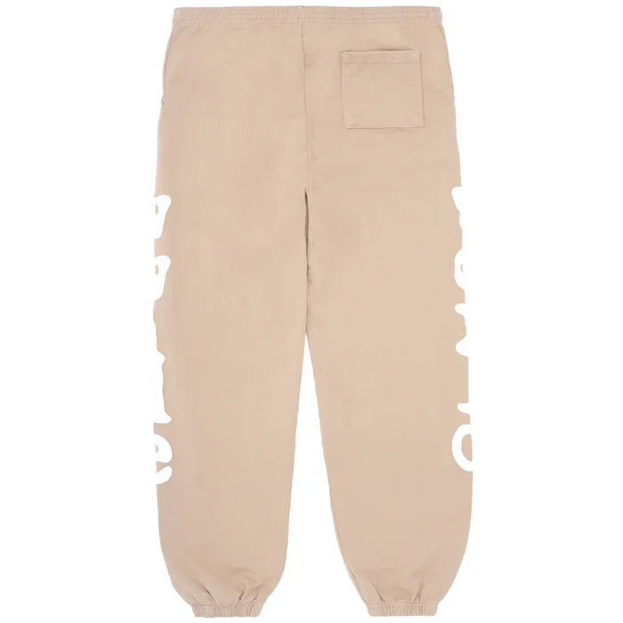 The 100% Cotton Sp5der Sweatpants for Men are beige streetwear jogger pants with a relaxed fit, side logo graphics, an elastic waistband and cuffs, and a right back pocket—offering signature comfort and style.