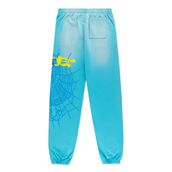 The 100% Cotton Sp5der Sweatpants are unisex blue jogger pants featuring a relaxed fit, spider web graphic with star details, elastic waistband and cuffs, plus a small back pocket.