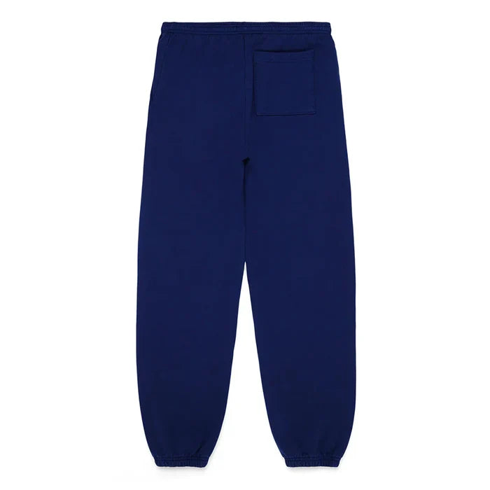 100% cotton Sp5der sweatpants in navy blue, unisex relaxed-fit jogger pants with pink logo and star graphics, featuring an elastic waistband, ankle cuffs, and a back right patch pocket—laid flat on a white background.
