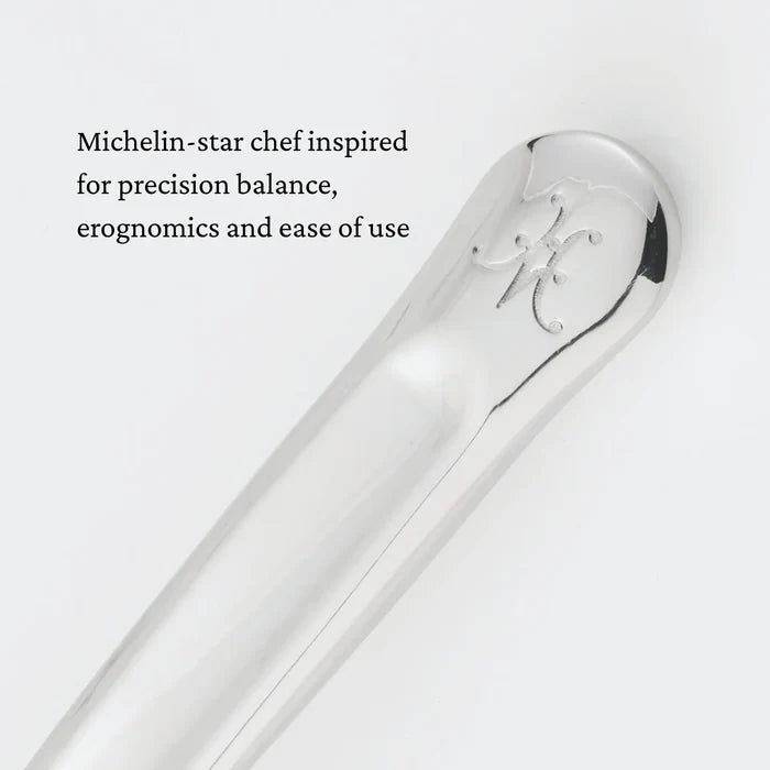 A close-up of a polished metal handle of the 10.5-inch Stainless Steel Pie & Cake Server by Hestan Provisions®, featuring an engraved logo at the end. Text beside it reads: Inspired by Michelin-star chefs for precision balance, ergonomics, and ease of use—crafted to complement Hestan Culinary and Provisions Serving Tools collections.