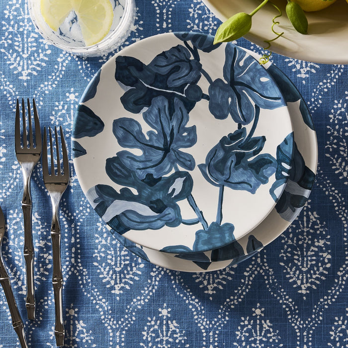 Bali 18/10 stainless steel flatware set with bamboo-inspired texture on a blue patterned tablecloth with floral plates.