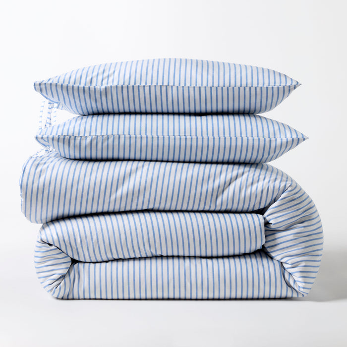 Stacked blue oxford thin stripe organic cotton duvet and shams set with tie closures.