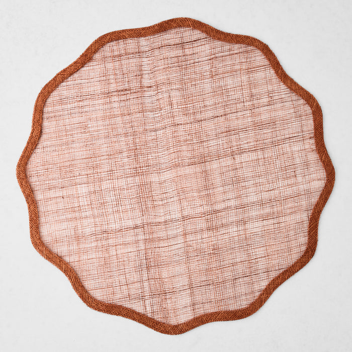 16-inch round brick red abaca fiber placemat with a semi-transparent woven texture and a solid scalloped border.