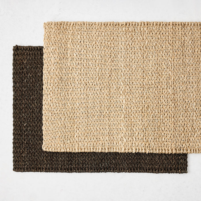 Two rectangular hand-woven abaca placemats in chocolate brown and natural tan, 19 by 14 inches, with a textured weave.