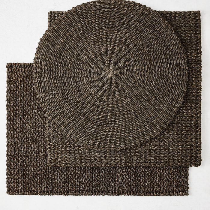 Round and square hand-woven abaca placemats in a rich chocolate brown, 16-inch diameter, textured natural fiber weave.