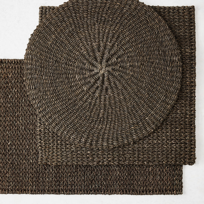 Chocolate brown square and round hand-woven abaca placemats with textured natural fiber weave.