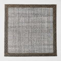 Chocolate brown square placemat made of woven abaca fibers with a semi-transparent center and solid border.