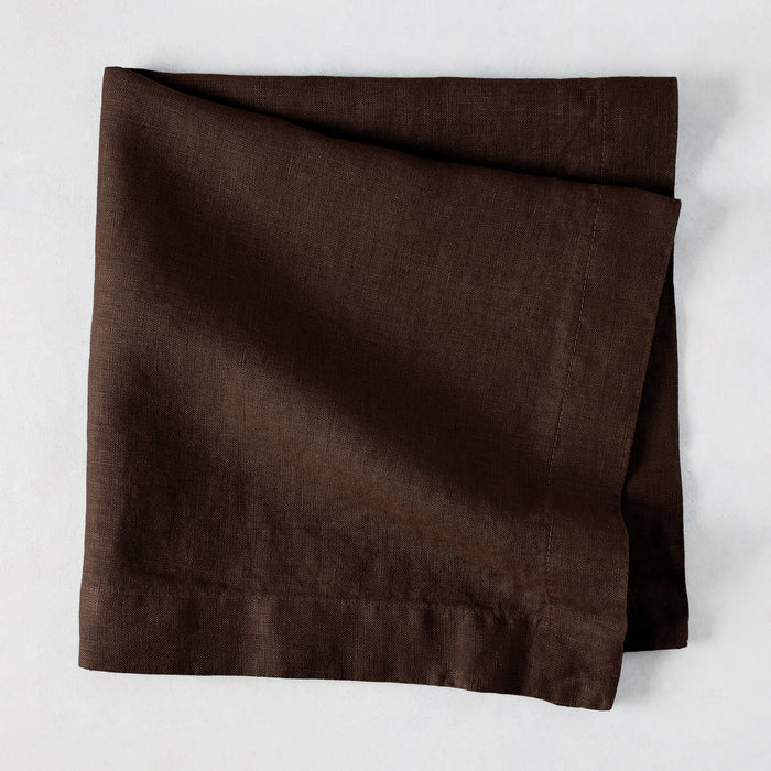 Cocoa HG hand-dyed 22" square brown linen napkin, folded on a light surface.
