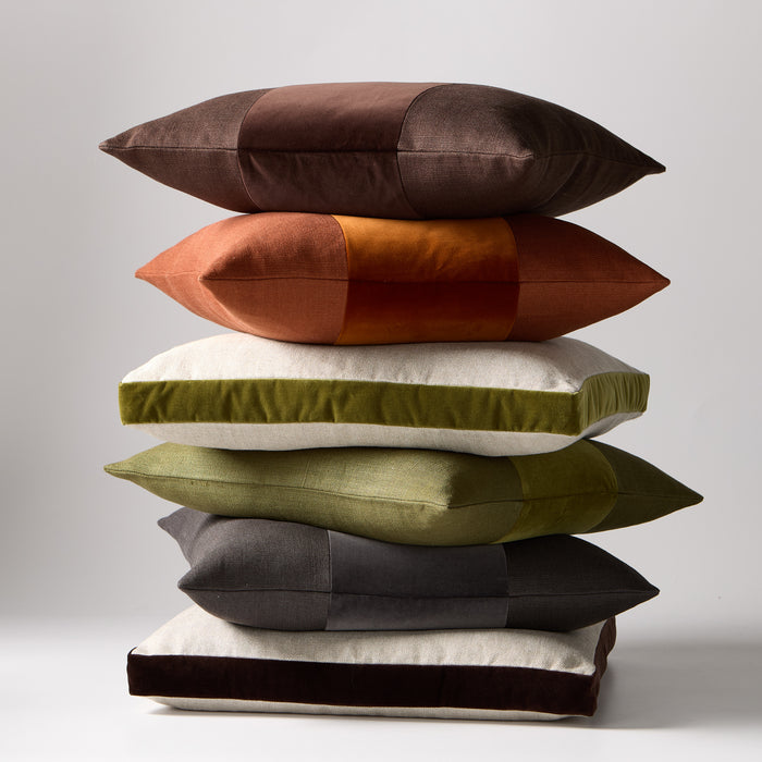 Stack of six Hudson Grace lumbar pillows: dark brown, rust, olive green, and charcoal velvet and linen.
