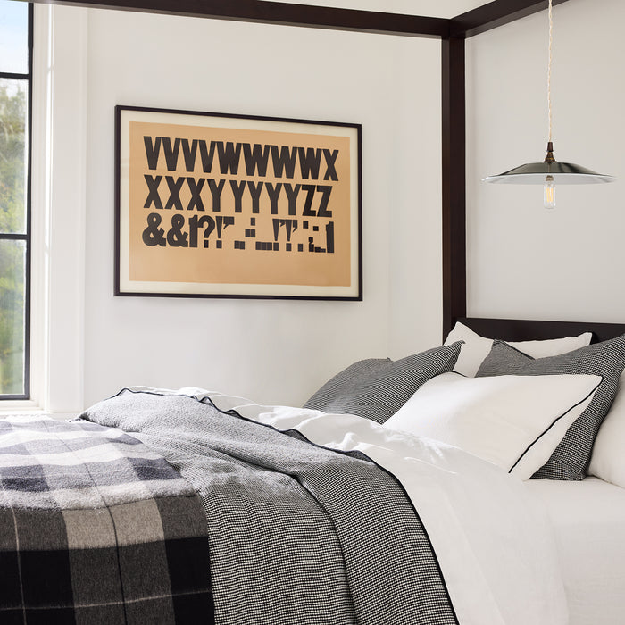 Diane Keaton + Hudson Grace Alpaca Charcoal Plaid Throw Blanket on a bed.