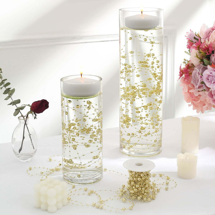 Elegant decorative candles in glass vases with gold accents and floral backdrop.