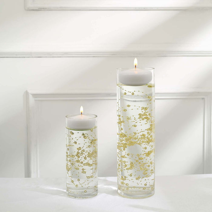 Gold bubble candles in glass holders on a white background.