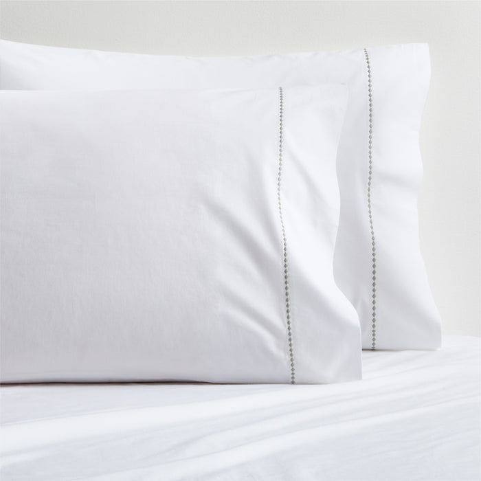 White percale pillowcases with grey diamond embroidered detail.