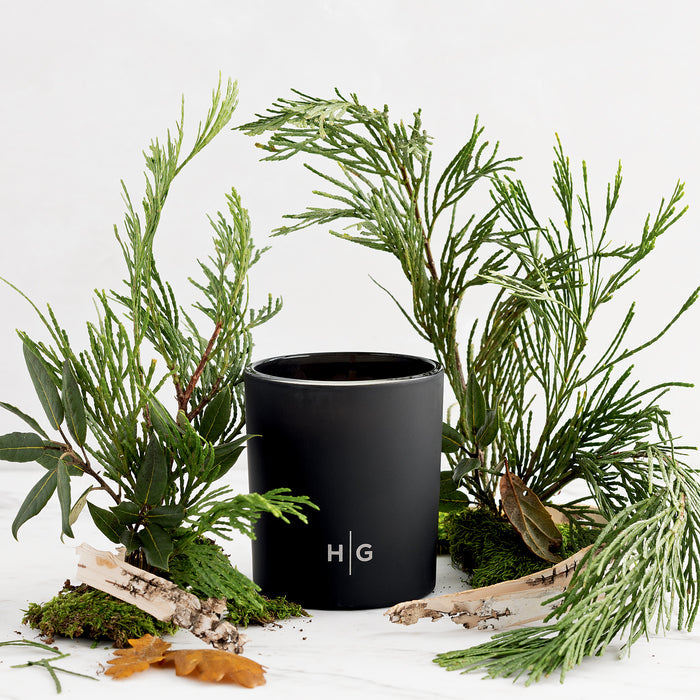 Hudson Grace Bleecker black matte glass room spray or diffuser with green foliage, moss, and birch bark.