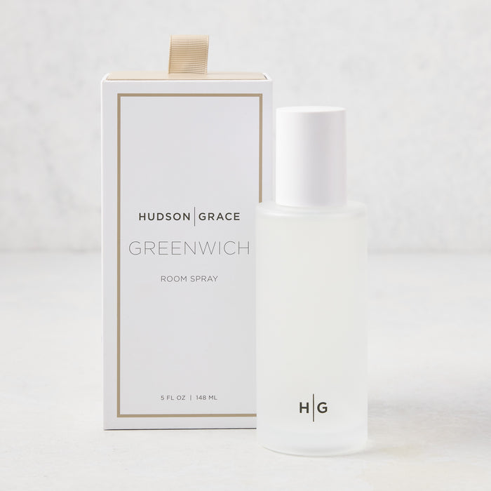 Hudson Grace Greenwich Room Spray: frosted glass bottle, white cap, next to white box with gold ribbon.