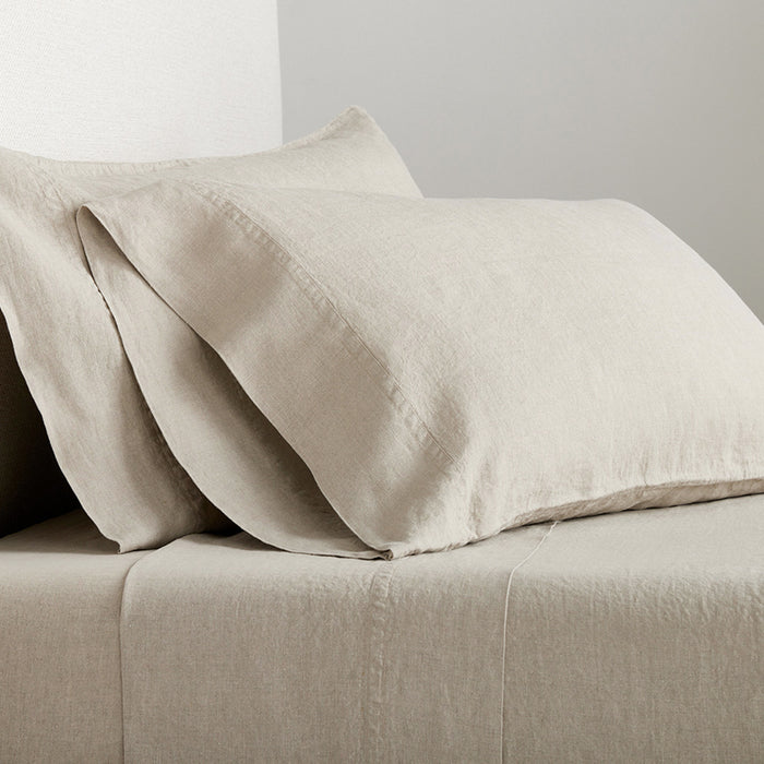 Set of 2 Khaki Washed-Linen Pillowcases with double-needle stitch detailing on a bed.