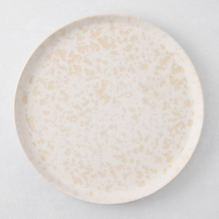 Natural Nuno Splatter 11" stoneware dinner plate with beige spots on a pale cream base.