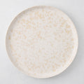 Natural Nuno Splatter 11" stoneware dinner plate with beige spots on a pale cream base.