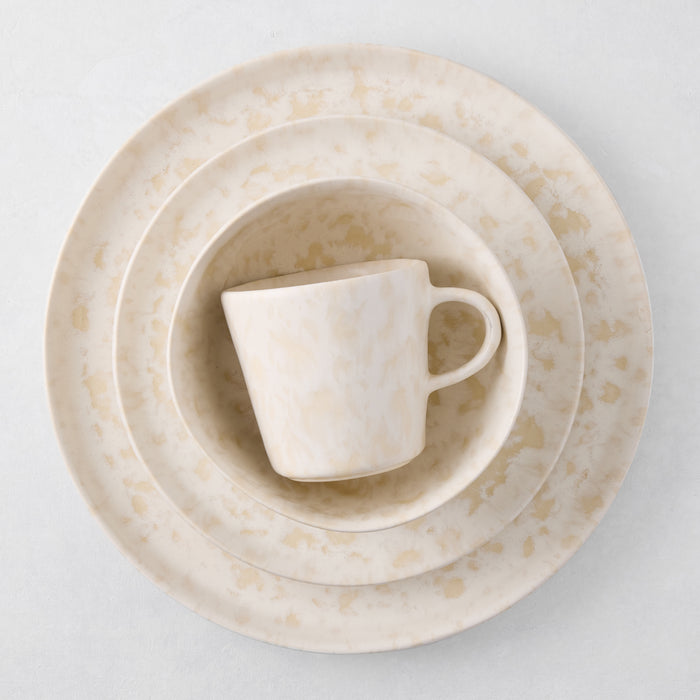 Natural Nuno Splatter stoneware salad plate with unique beige spots on a pale cream base.
