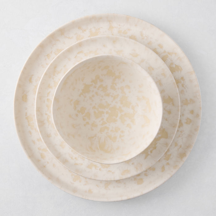 Natural Nuno Splatter stoneware salad plate, dinner plate, and bowl with beige spots on a cream base.
