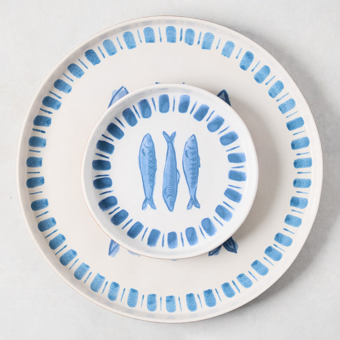 Round terracotta serving platter with blue sardine design and matching small plate.