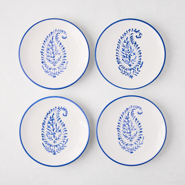 Four white Peter Dunham + Hudson Grace Blue Hand-Painted Kashmir Paisley Appetizer Plates with blue rims.