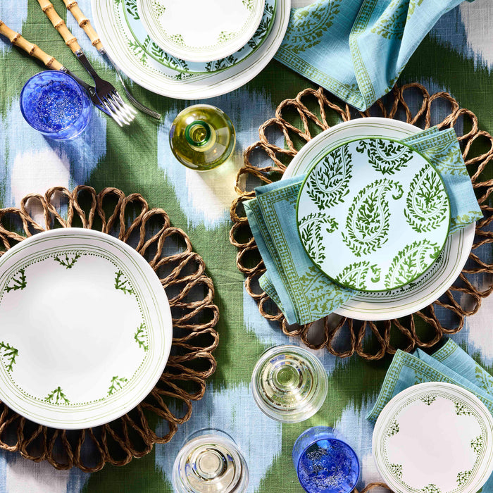 Peter Dunham + Hudson Grace Green Fez hand-painted dinner plate with border on a woven placemat.