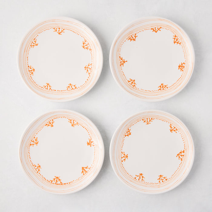Four white Peter Dunham + Hudson Grace Orange Fez appetizer plates with hand-painted coral borders.