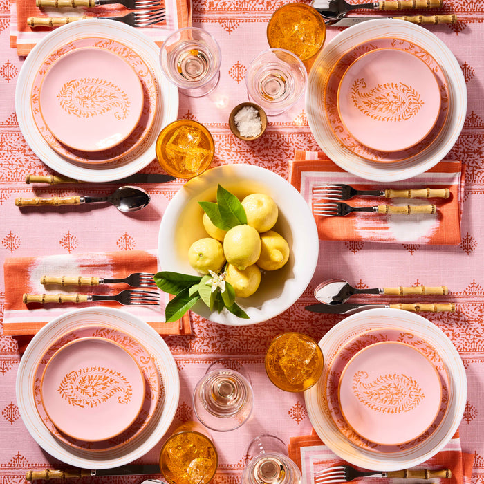 Pink Kashmir hand-painted paisley salad plates by Peter Dunham + Hudson Grace on a patterned pink tablecloth.