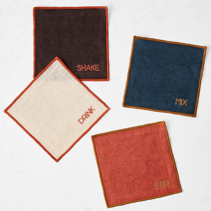 Set of four 5.5-inch square linen coasters in brown, navy, khaki, and brick with embroidered bar-themed text and stitched edges.