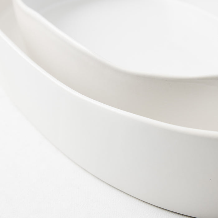 Small oval stoneware baker in matte white with a smooth, minimalist design and curved edges.