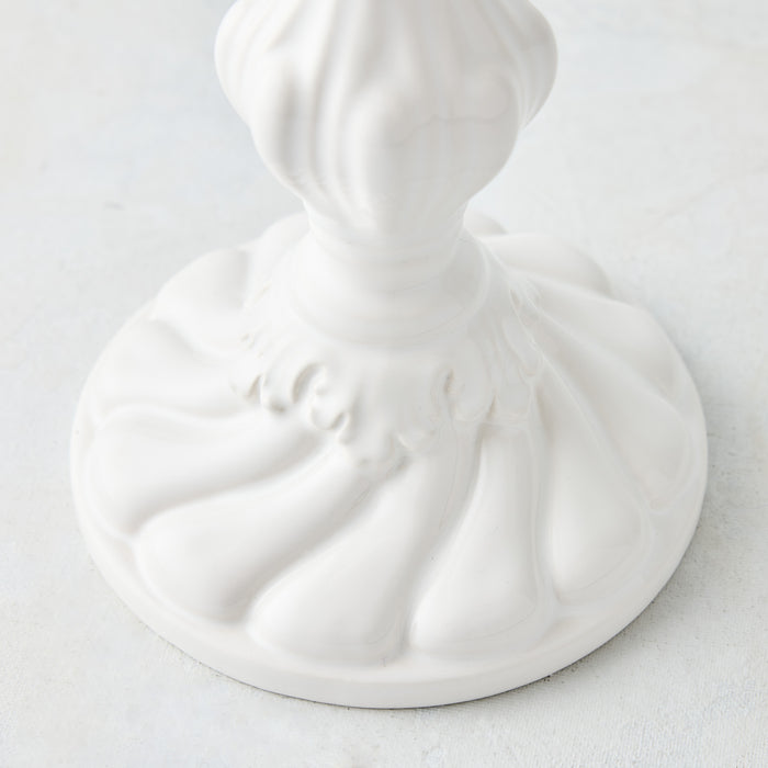 Small white ceramic Tosca candlestick with a decorative fluted base and glossy glaze finish.
