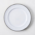 White enamelware salad plate with a dark rim.