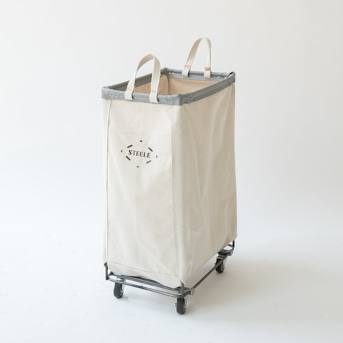 Tall Steele canvas caddie in natural cotton with a steel frame, grey trim, and rolling caster wheels on a white background.